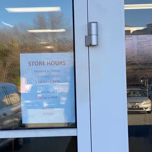 a store hours sign in the window