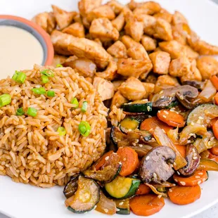 a plate of rice, vegetables, and chicken