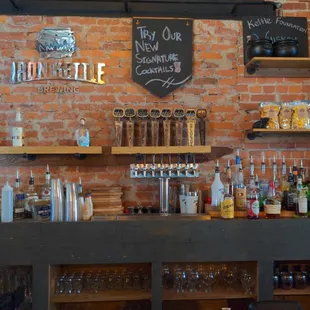 a brick wall with shelves of liquor