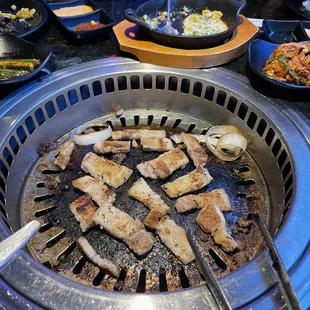 a variety of foods being cooked on a grill