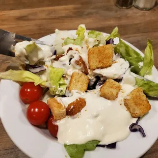 a plate of salad with croutons