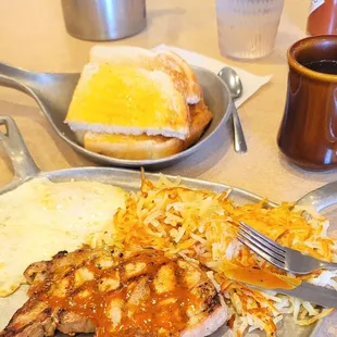 Yummers! Grilled pork chop two eggs over medium hash browns sourdough toast coffee a little Heinz 57 on top of the chop
