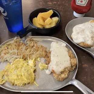 a breakfast of eggs, hash browns, and fruit