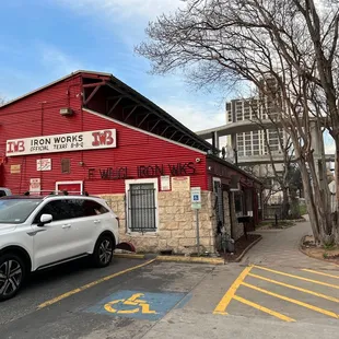a white suv parked in front of a red building