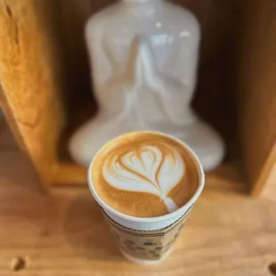 a cup of coffee with a statue in the background