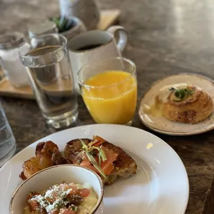 a plate of food and a glass of orange juice