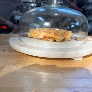 a waffle on a cutting board under a clochet