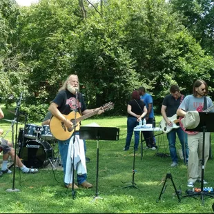 a group of people playing music in the park