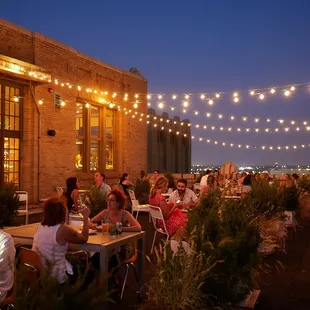 a group of people sitting at tables outside at night