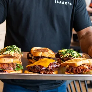 a man holding a tray of sandwiches