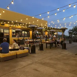 a restaurant with outdoor seating and string lights