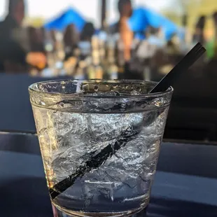 a glass of water with ice and a spoon