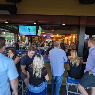 a large group of people sitting at a bar