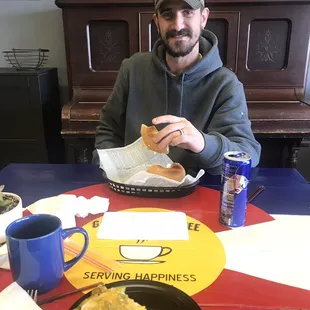 a man sitting at a table with a plate of food