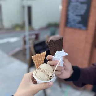 a person holding a cup of ice cream