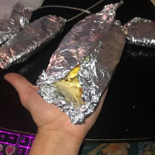 a hand holding a taco