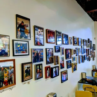 a wall full of framed pictures