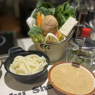 a bowl of noodles, a bowl of broccoli, a bowl of tofu, a bowl of