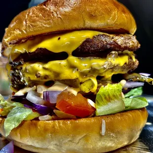 a cheeseburger with lettuce and tomato