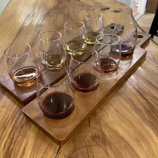 a flight of wine glasses on a wooden table