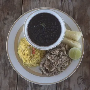 Classic Lechon asado with cuban yellow rice, black beans and yuca con mojo