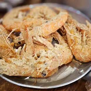 a plate of fried shrimp on a wooden table