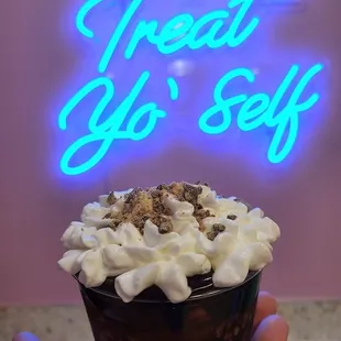 a hand holding a cup of ice cream