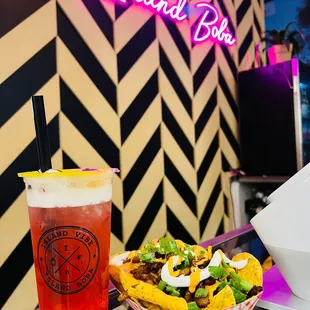 a plate of nachos and a drink