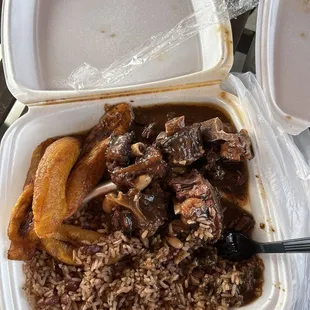 Oxtail plate with a side of rice and peas and plantains.