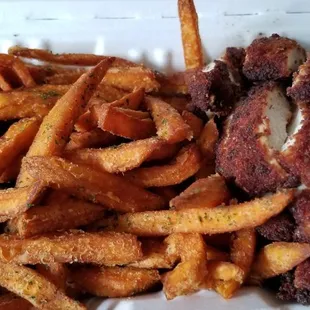 fried chicken and sweet potato fries in a styrofoam styrofoam container