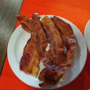 a plate of bacon and a bowl of soup