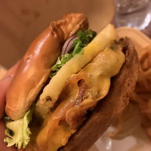 a hand holding a cheeseburger