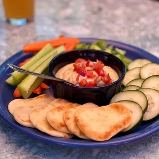 a plate of food with crackers and dip