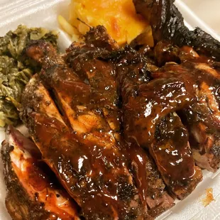 a plate of ribs, potatoes, and broccoli