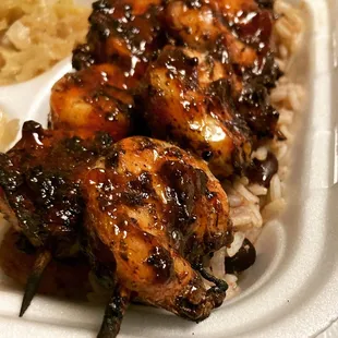 chicken skewers on a bed of rice