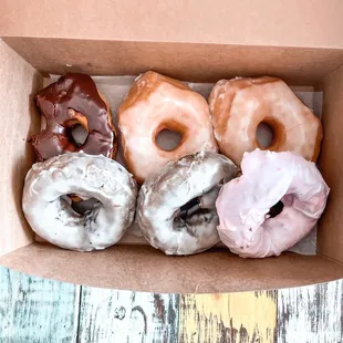 From left to right: glazed with chocolate icing, original glazed, (front row) blueberry, then Very Berry.