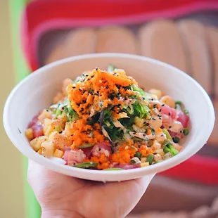 a hand holding a bowl of food