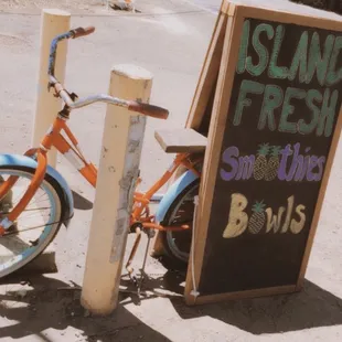 a bicycle parked next to a sign