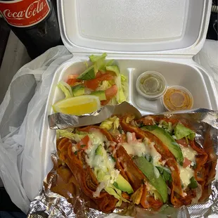 a sandwich and salad in a styrofoam container