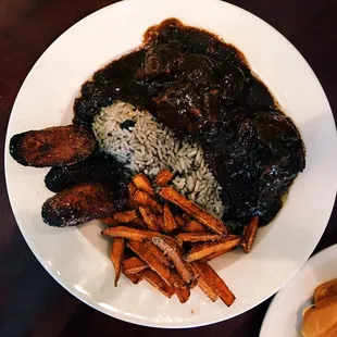 Braised oxtails with rice, fries, and plantains