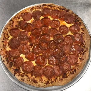 a pepperoni pizza on a pan