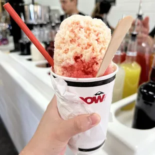 a hand holding a cup of ice cream