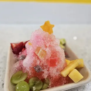 Custom half water melon and half Lychee (half serving) with fresh fruit toppings. I would definitely recommend the green Mango and grapes !