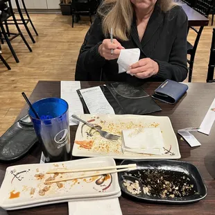 Plates all over. Payment in progress NO one clean the table so make a place to sign the check.