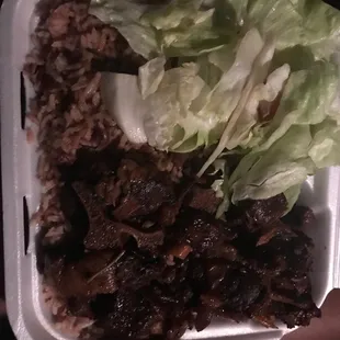 a hand holding a styrofoam container of food