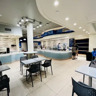 Clean white modern decor with cool blue glass tiles wrapped around the counters