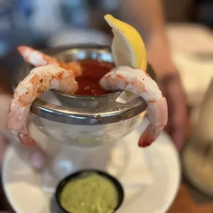 a shrimp cocktail with a lemon wedge
