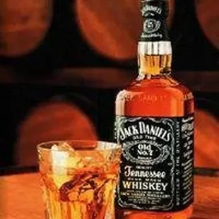 a bottle of jack daniels whiskey next to a glass of whiskey
