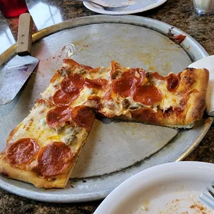 a half eaten pepperoni pizza