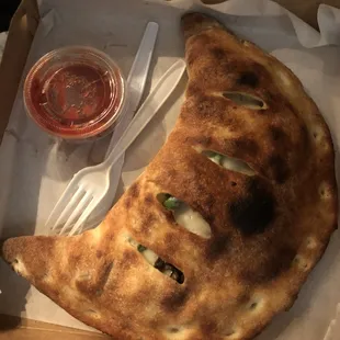 This is the huge veggie calzone with its side of red sauce.